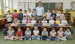 Schulklasse der Volksschule Kuchl hört aus dem Kinderbuch „Die singende Familie aus Salzburg“ von Margret Springl.